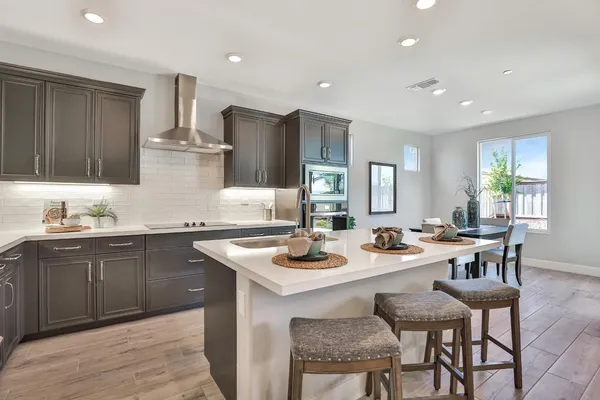 a kitchen with a dining table chairs and refrigerator