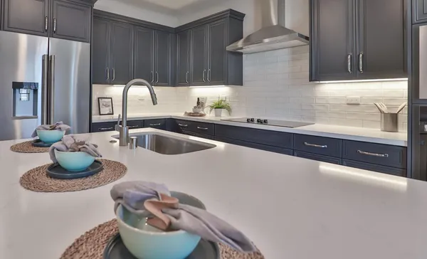 a kitchen with a sink and a stove with wooden cabinets