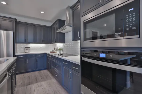 a kitchen with stainless steel appliances granite countertop a stove a sink and a refrigerator