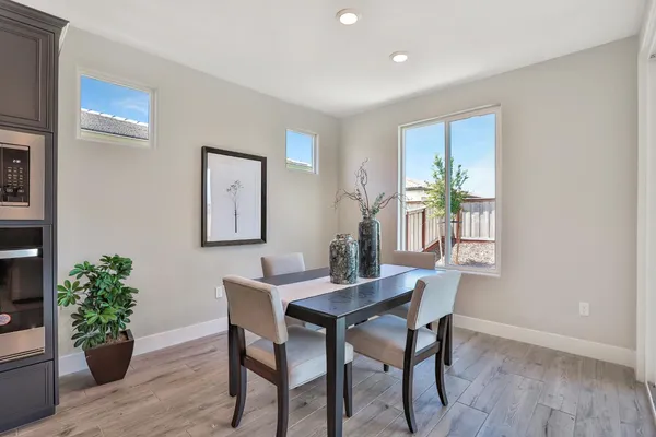 a dining room with furniture potted plants and wooden floor