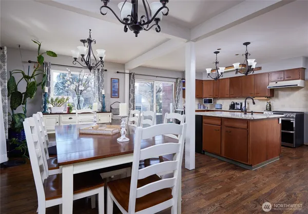 a kitchen with kitchen island a stove a table and chairs in it