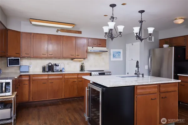 a kitchen with a sink refrigerator and cabinets