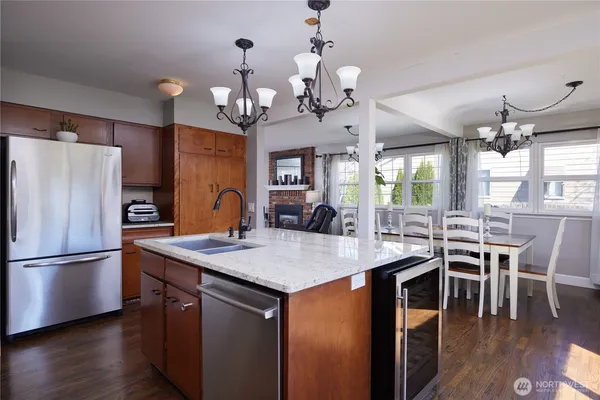 a view of a dining room with furniture a chandelier and wooden floor