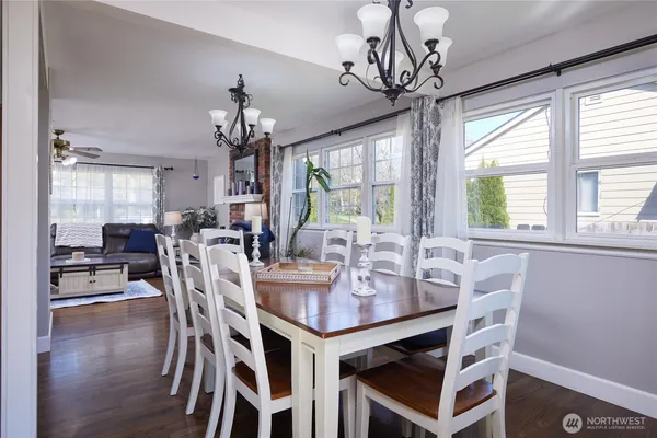 a view of a dining room with furniture a chandelier and wooden floor