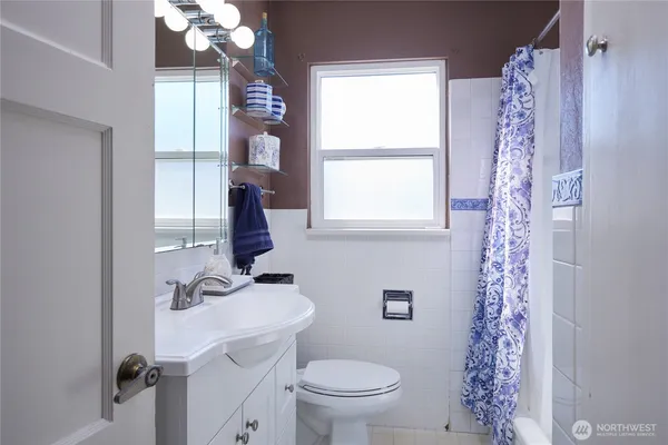 a bathroom with a sink a toilet and shower curtain