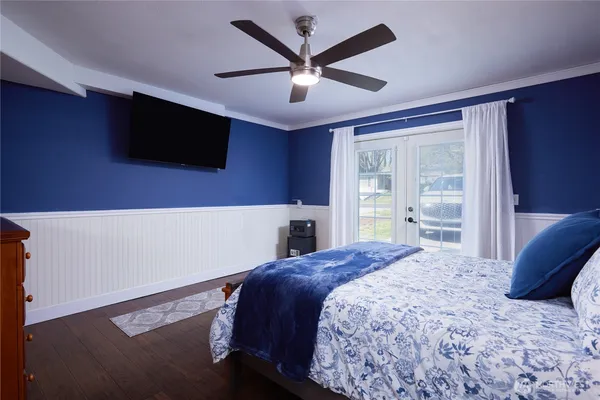 a bedroom with a large bed and a flat tv screen