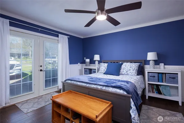 a bedroom with a bed and a bookshelf with wooden floor