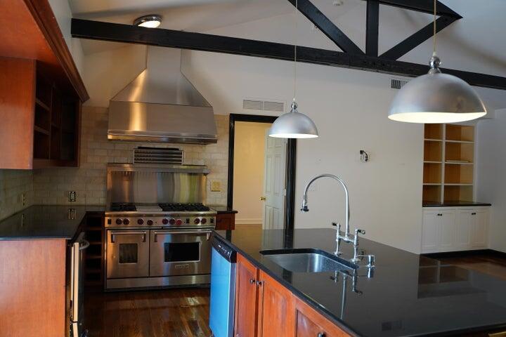 5215 North Flagler Drive West Palm Beach, FL 33407 - Photo 15 of 37 a kitchen with kitchen island granite countertop a sink stainless steel appliances and cabinets