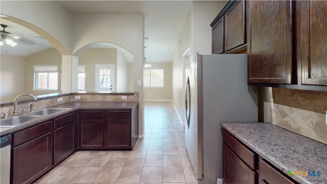 a kitchen with stainless steel appliances granite countertop a refrigerator a sink and dishwasher