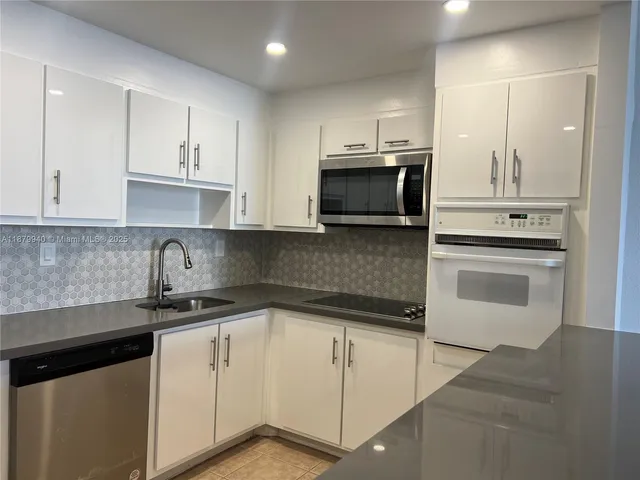 a kitchen with stainless steel appliances white cabinets and a sink