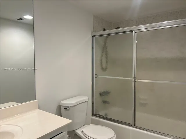 a bathroom with a shower a toilet and a sink