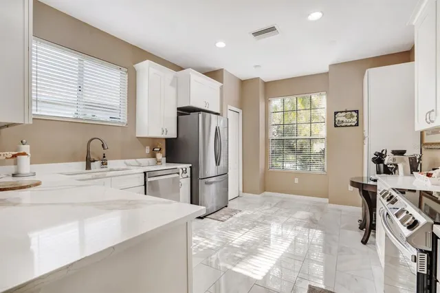 a kitchen with a refrigerator a sink dishwasher a stove and a refrigerator with wooden floor