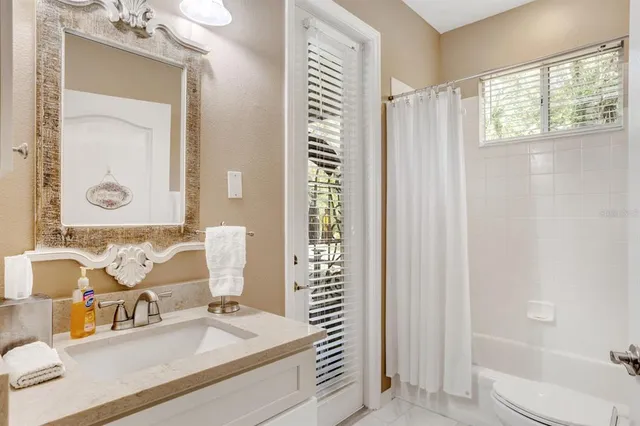 a bathroom with a sink a toilet and shower curtain