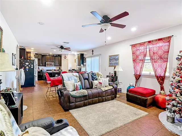 a living room with furniture kitchen view and a window