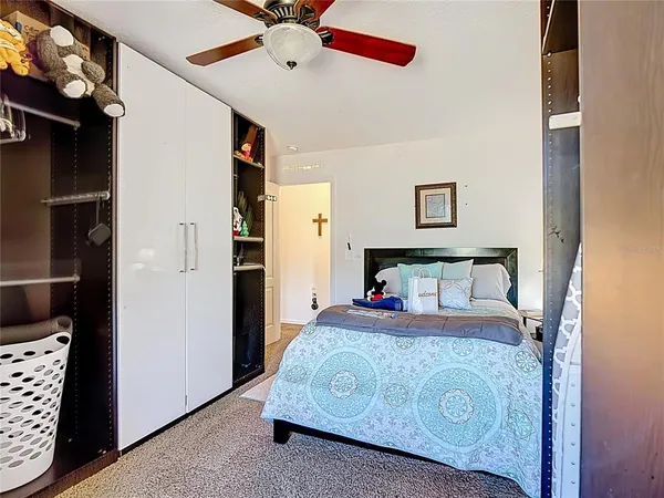 a bedroom with a bed and a ceiling fan