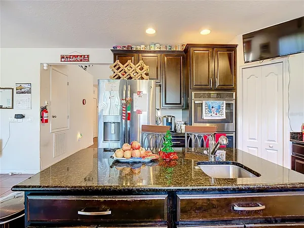 a kitchen with kitchen island granite countertop a refrigerator and a stove
