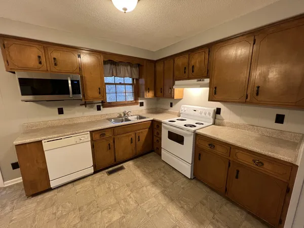 a kitchen with a sink stove and microwave