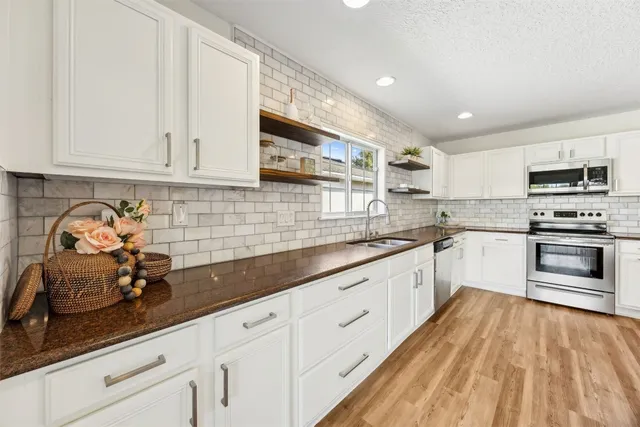 a kitchen with stainless steel appliances a refrigerator sink and microwave