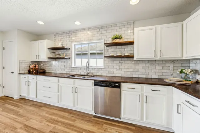 a kitchen with granite countertop white cabinets and white appliances