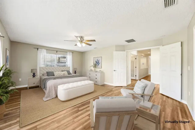 a spacious bedroom with a bed and glass window