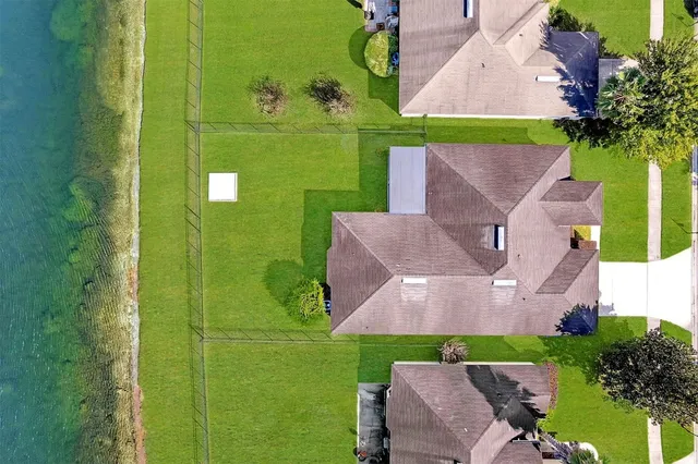 an aerial view of a house with swimming pool and ocean view
