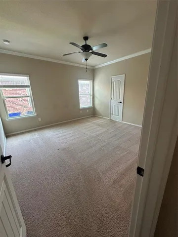 an empty room with windows and fan