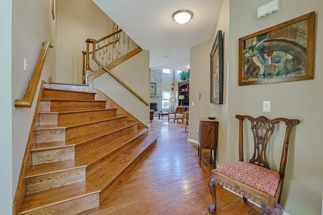 a hallway with stairs and wooden floor