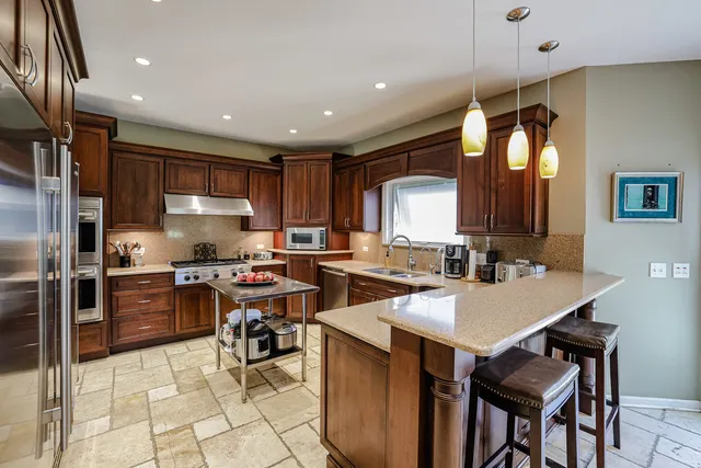 a kitchen with cabinets a sink and chairs