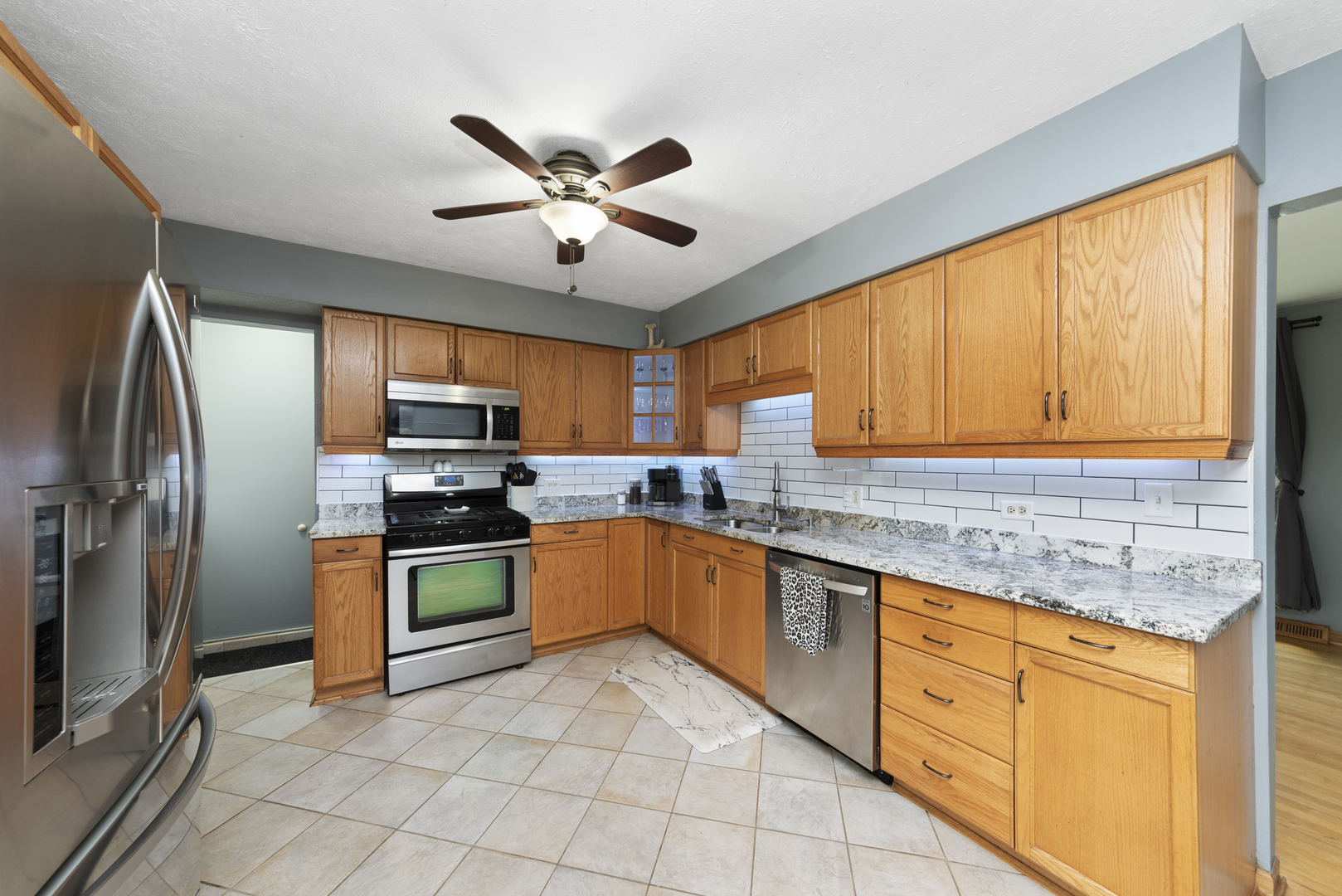 943 Sumner Street Addison, IL 60101 - Photo 3 of 20 a kitchen with stainless steel appliances granite countertop a refrigerator a sink dishwasher a stove with wooden cabinets and floor