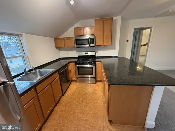 a kitchen with granite countertop sink stainless steel appliances and cabinets