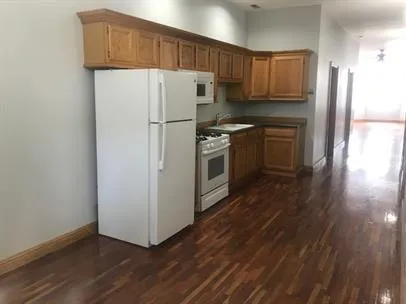 a kitchen with a refrigerator sink and cabinets