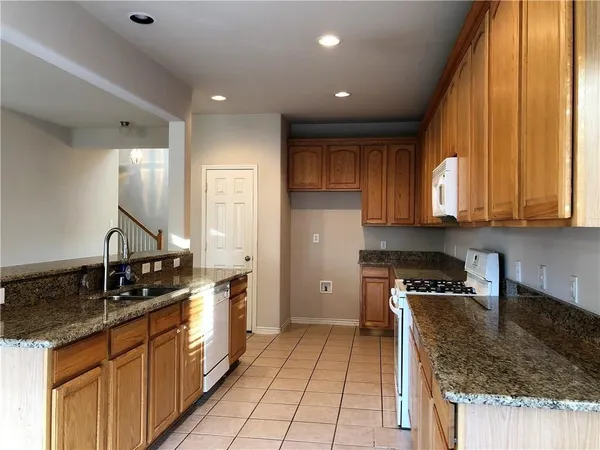 a kitchen with stainless steel appliances granite countertop a sink stove and cabinets