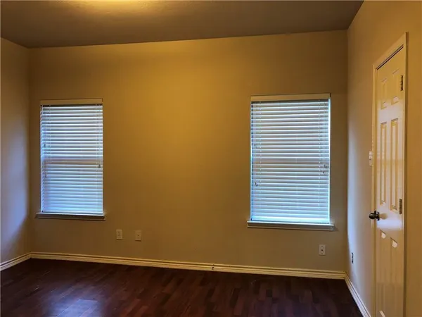 a view of a small space with wooden floor and a window