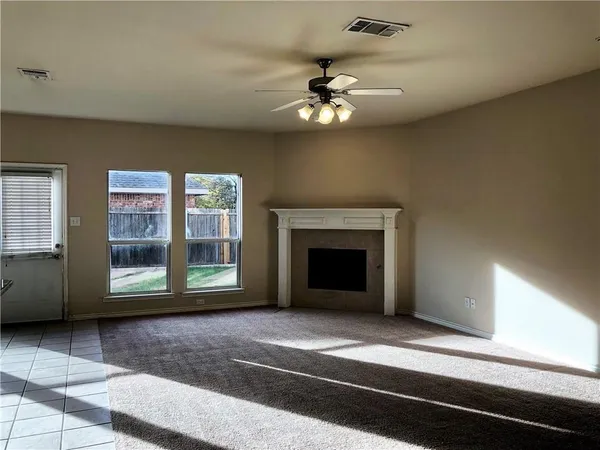a view of an empty room with a fireplace and a window
