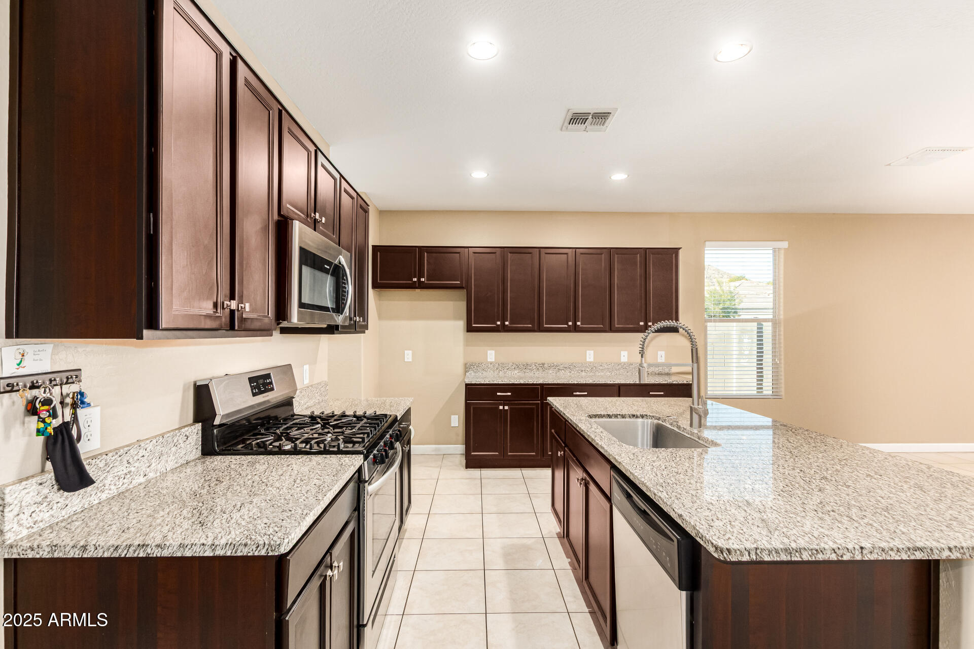 4170 West South Butte Road San Tan Valley, AZ 85144 - Photo 11 of 47 a kitchen with stainless steel appliances granite countertop a sink stove and cabinets
