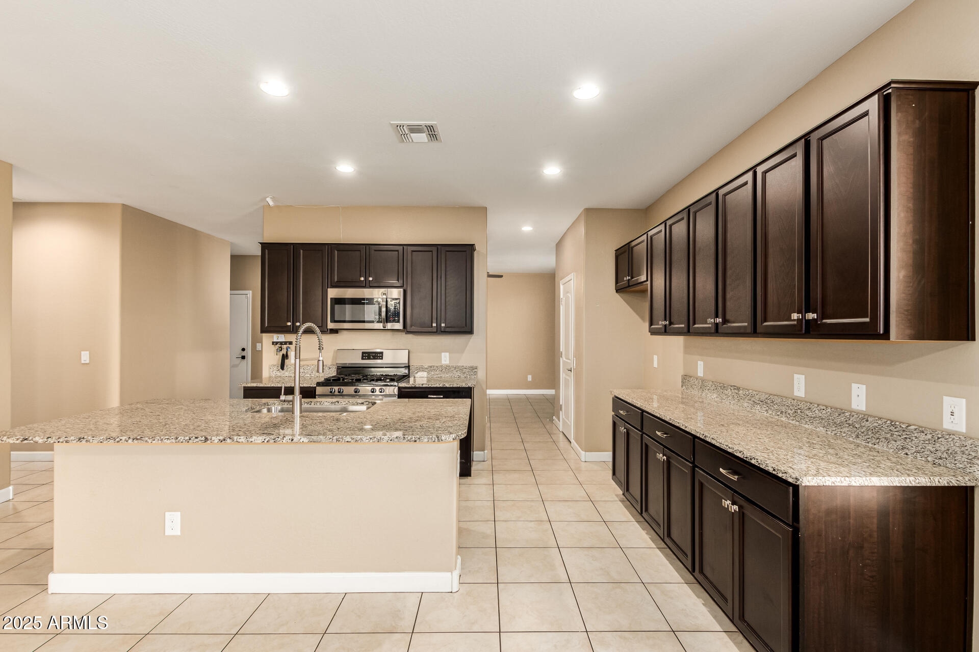 4170 West South Butte Road San Tan Valley, AZ 85144 - Photo 13 of 47 a kitchen with stainless steel appliances granite countertop a sink stove and cabinets