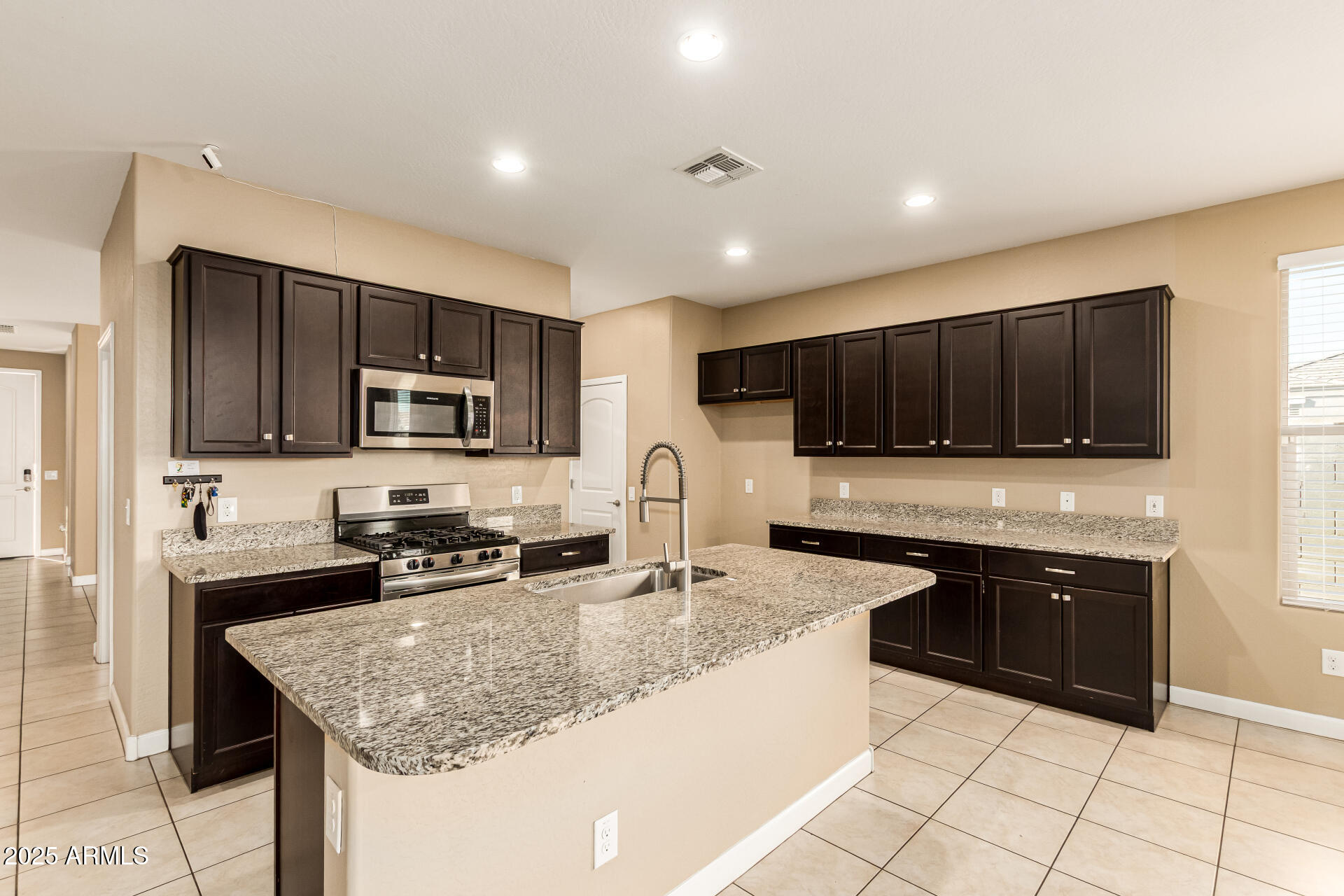 4170 West South Butte Road San Tan Valley, AZ 85144 - Photo 14 of 47 a kitchen with stainless steel appliances granite countertop a sink stove microwave and refrigerator