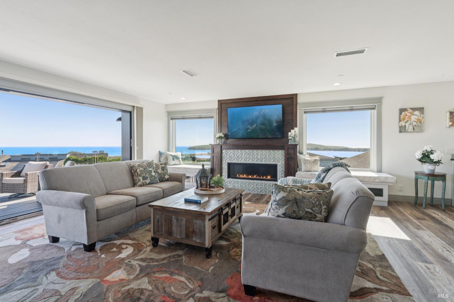88 Cypress Loop Bodega Bay, CA 94923 - Photo 24 of 88 Admire views of Doran Beach, Bodega Head, Bodega Harbor and Point Reyes out the Anderson dual pane windows and LaCantina sliding glass door. The open space comes complete with a decorative seafoam gas fireplace, recessed lighting, window seats with storage cubbies, and motored window shades.