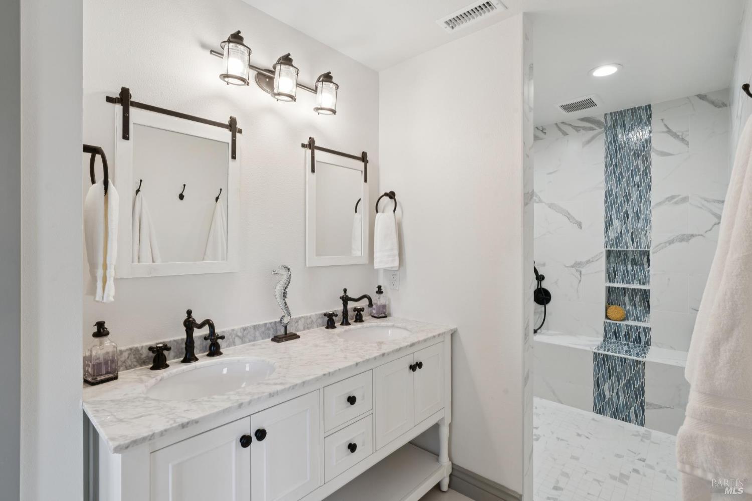 88 Cypress Loop Bodega Bay, CA 94923 - Photo 53 of 88 Primary ensuite bathroom with a large walk-in shower, dual sinks, and vanity nook. The walk-in shower includes a bench, multiple niches, and three shower heads.
