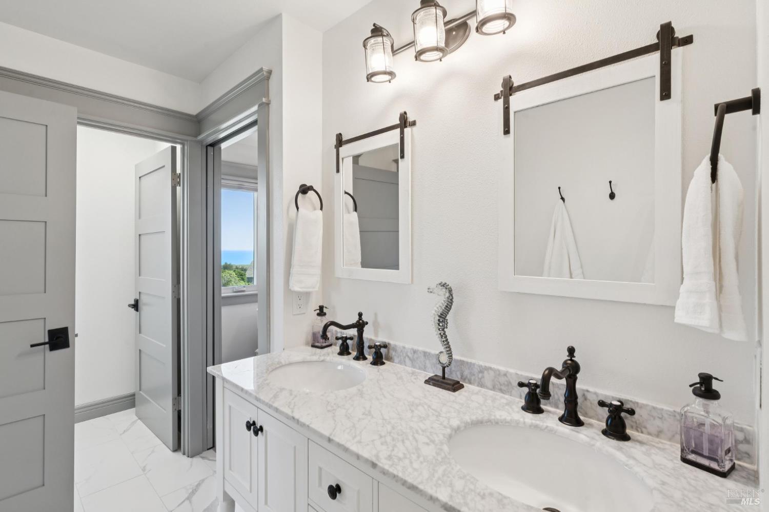 88 Cypress Loop Bodega Bay, CA 94923 - Photo 55 of 88 Primary ensuite bathroom with a large walk-in shower, dual sinks, and vanity nook. The walk-in shower includes a bench, multiple niches, and three shower heads.