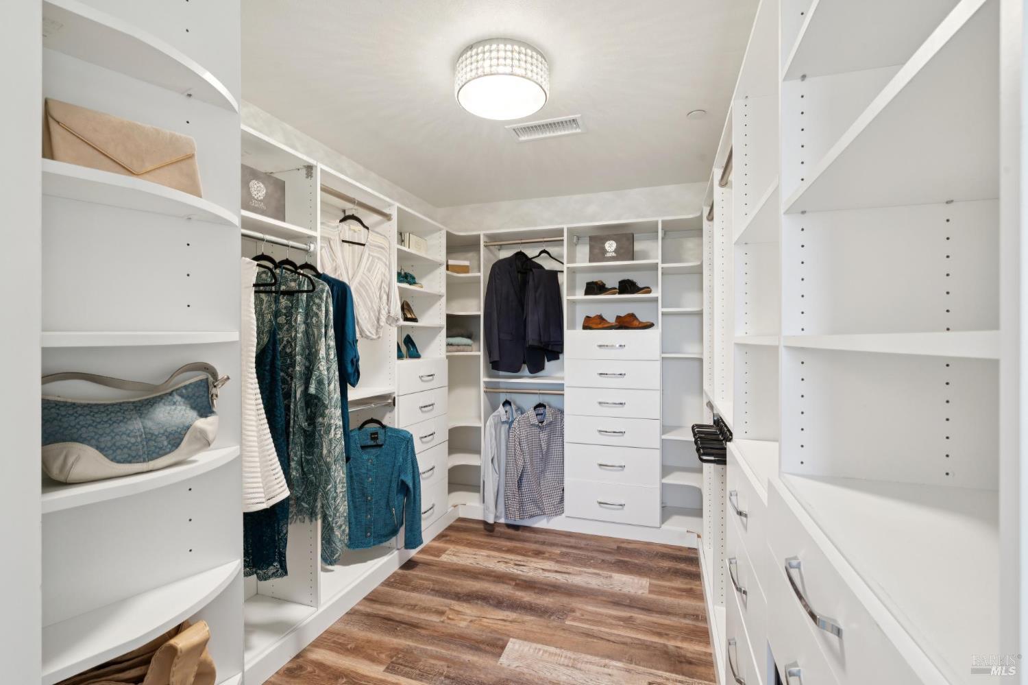 88 Cypress Loop Bodega Bay, CA 94923 - Photo 56 of 88 Large walk-in closet in primary bedroom with built-in shelving, drawers & awesome rotating shoe/purse rack. Avoid needing a dresser with a closet this size.