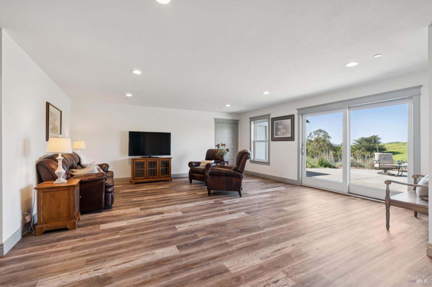 88 Cypress Loop Bodega Bay, CA 94923 - Photo 61 of 88 Lower-level family room features a sliding glass door opening to the back patio, showcasing expansive rolling hillside views. A private setting enhanced by the natural surroundings of Brooks Gulch. 4-car garage can be accessed through the door see in the photo.