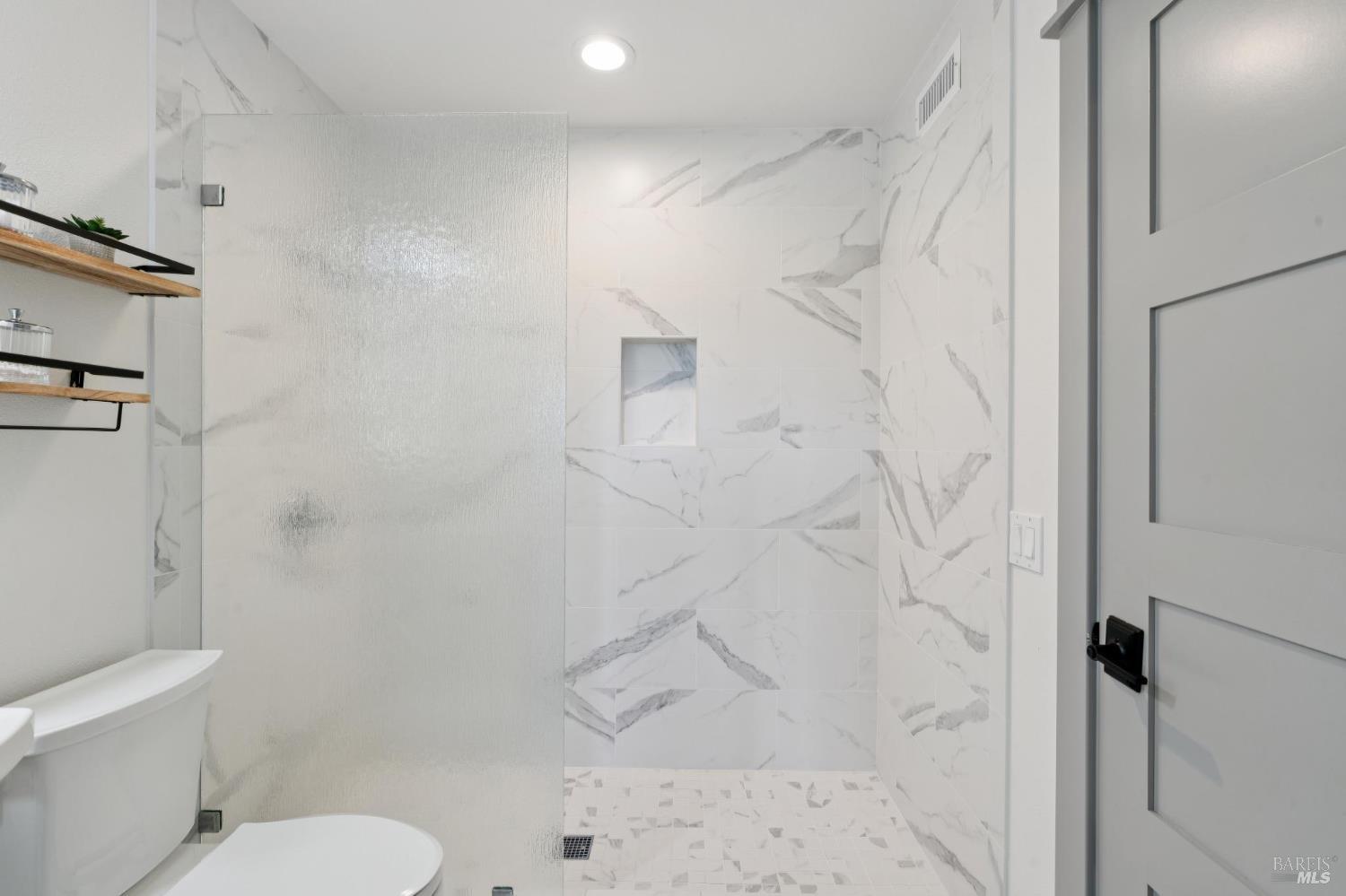 88 Cypress Loop Bodega Bay, CA 94923 - Photo 69 of 88 Dual-entry bathroom on the main level with modern tile floors, backlit mirror, pedestal sink and shower stall featuring a rain tempered glass panel and marble tile.