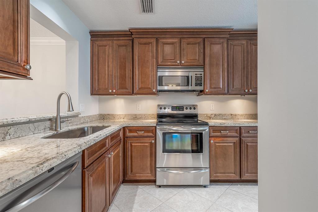 801 Southeast 16th Court, Unit 11 Fort Lauderdale, FL 33316 - Photo 20 of 49 a kitchen with granite countertop a sink and stove top oven