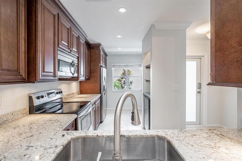 801 Southeast 16th Court, Unit 11 Fort Lauderdale, FL 33316 - Photo 23 of 49 a kitchen with stainless steel appliances granite countertop a sink and a refrigerator