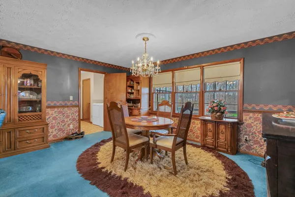 a dining room with furniture a chandelier and wooden floor