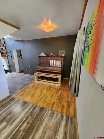 a view of a room with wooden floor and furniture