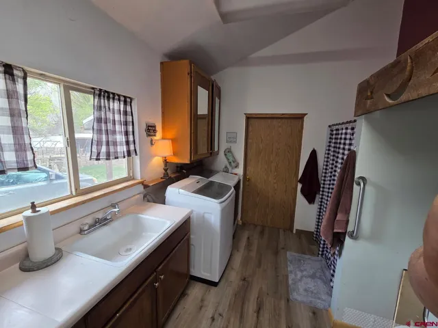 a kitchen with sink a refrigerator and wooden floor