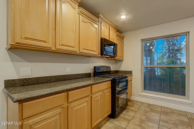 a kitchen with granite countertop a sink and cabinets