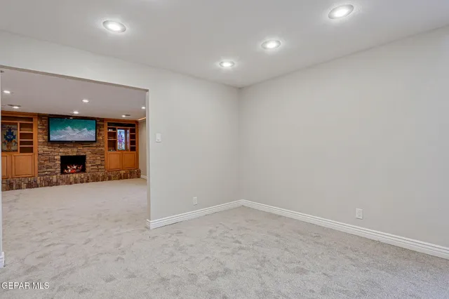 a view of an empty room with a fireplace and a window
